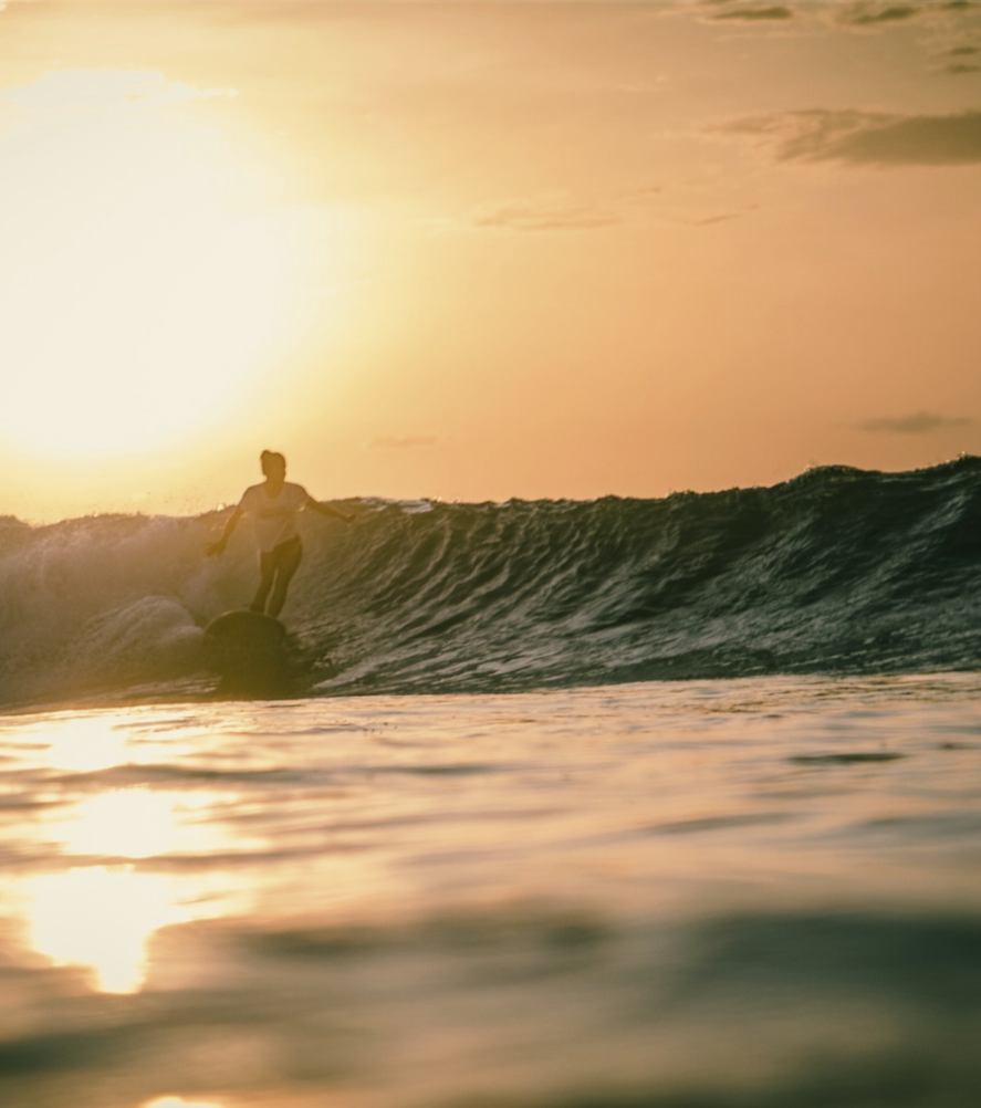 aloita sunset surfing - woman is surfing at sunset